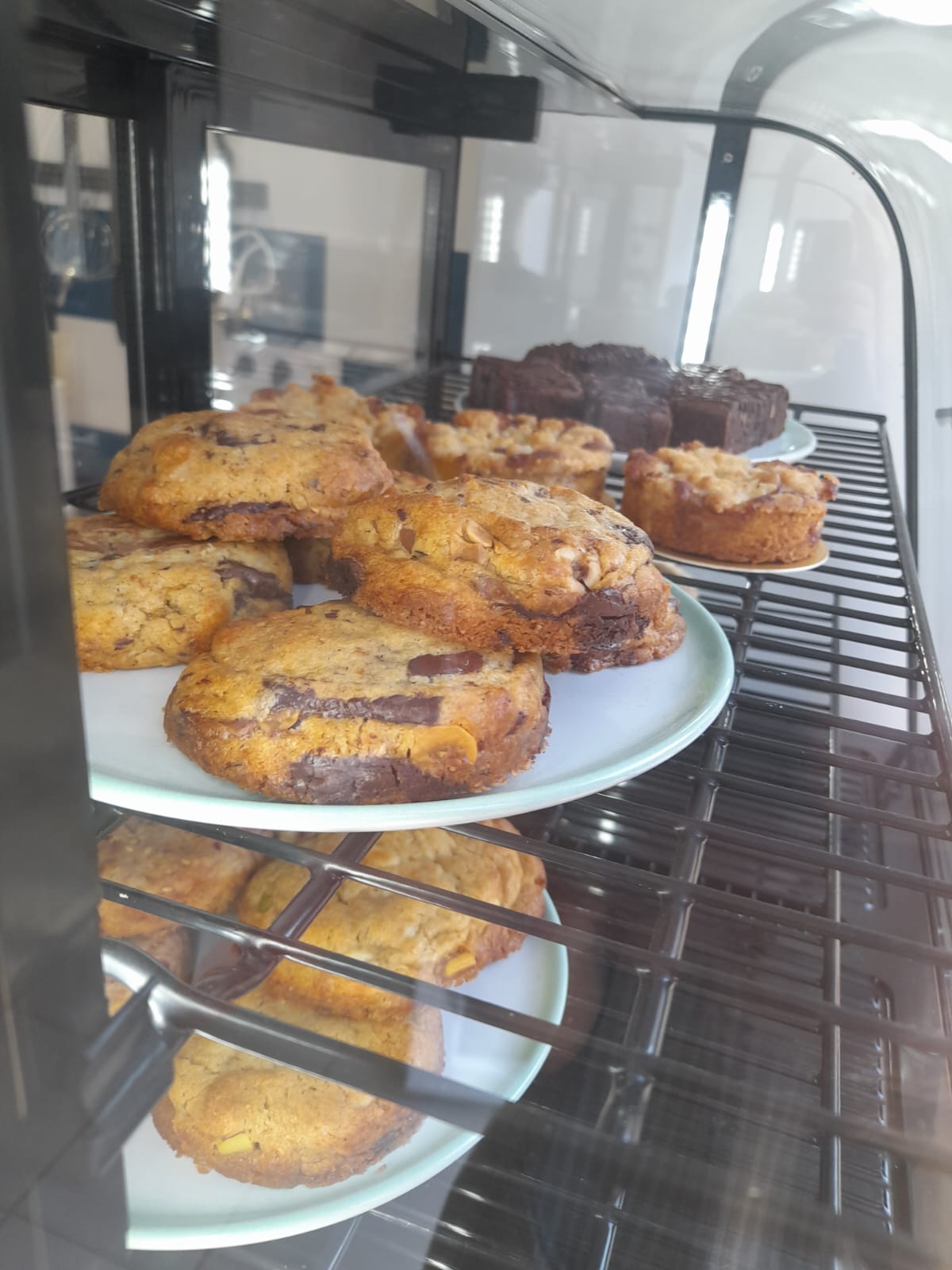 Vitrine de la pâtisserie : cookies aux pépites de chocolat et gourmandises sur des présentoirs
